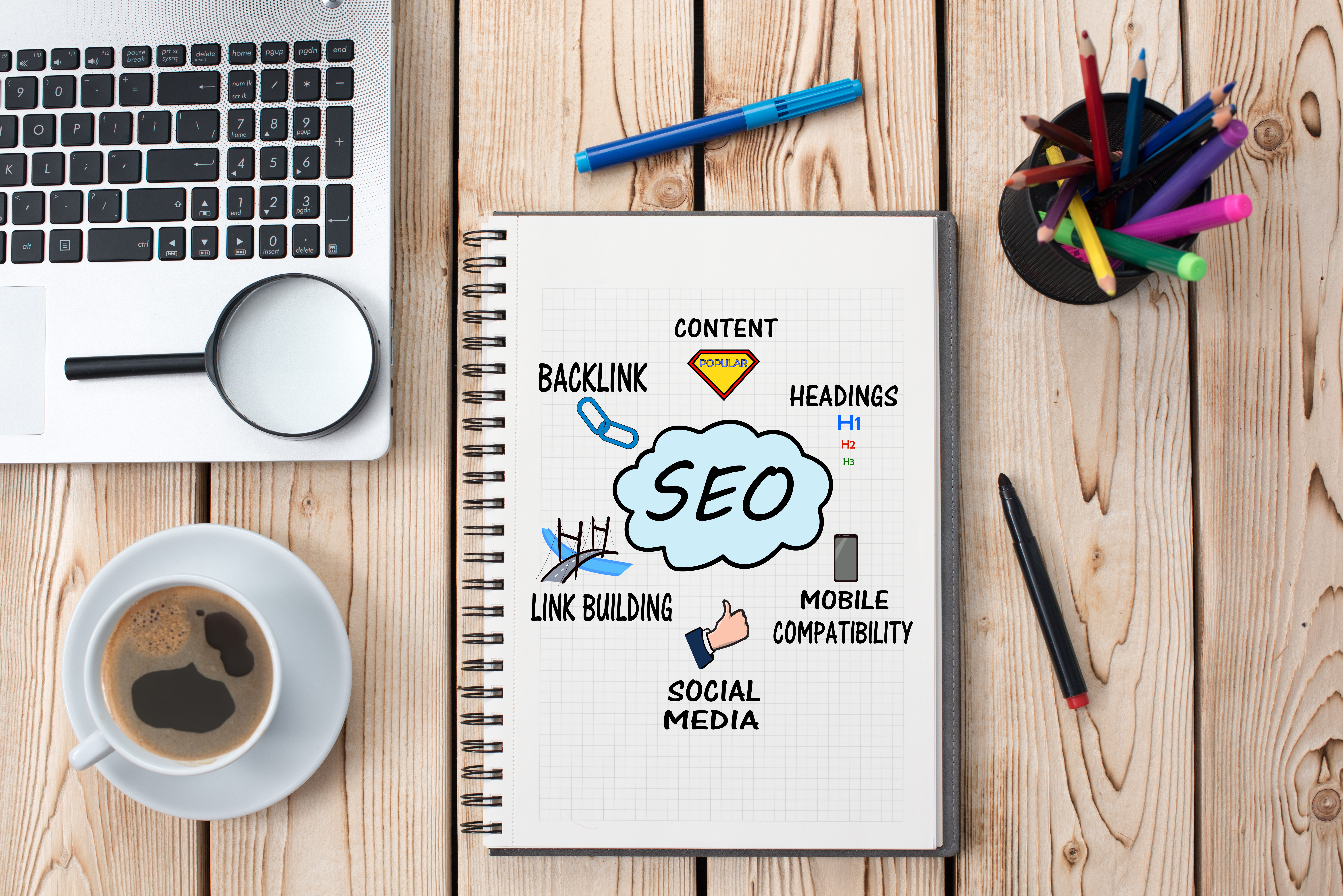 notebook on a table with a drawing of a thought bubble that says SEO