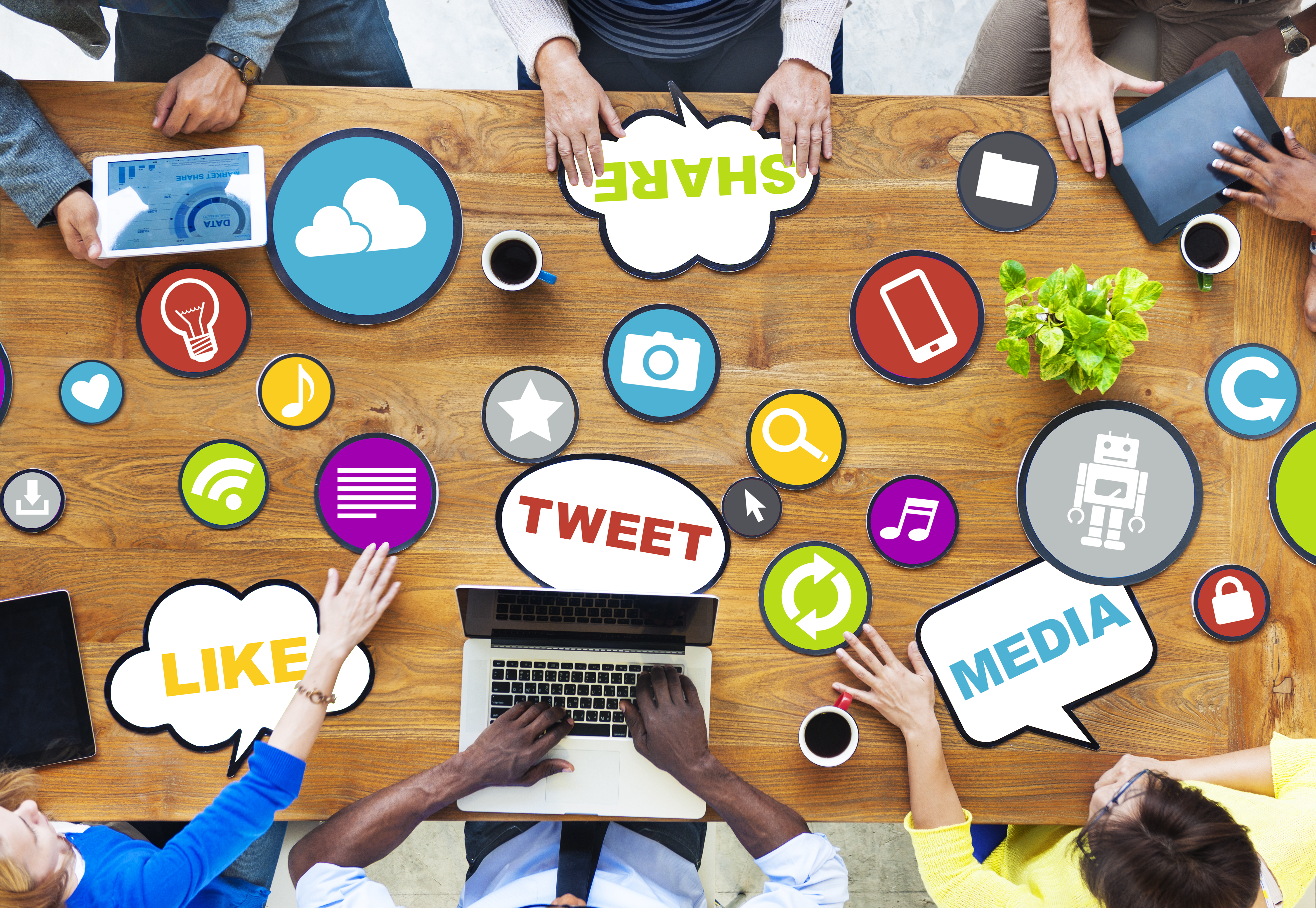 Overhead Shot of a group working at a table with logos of many social media companies